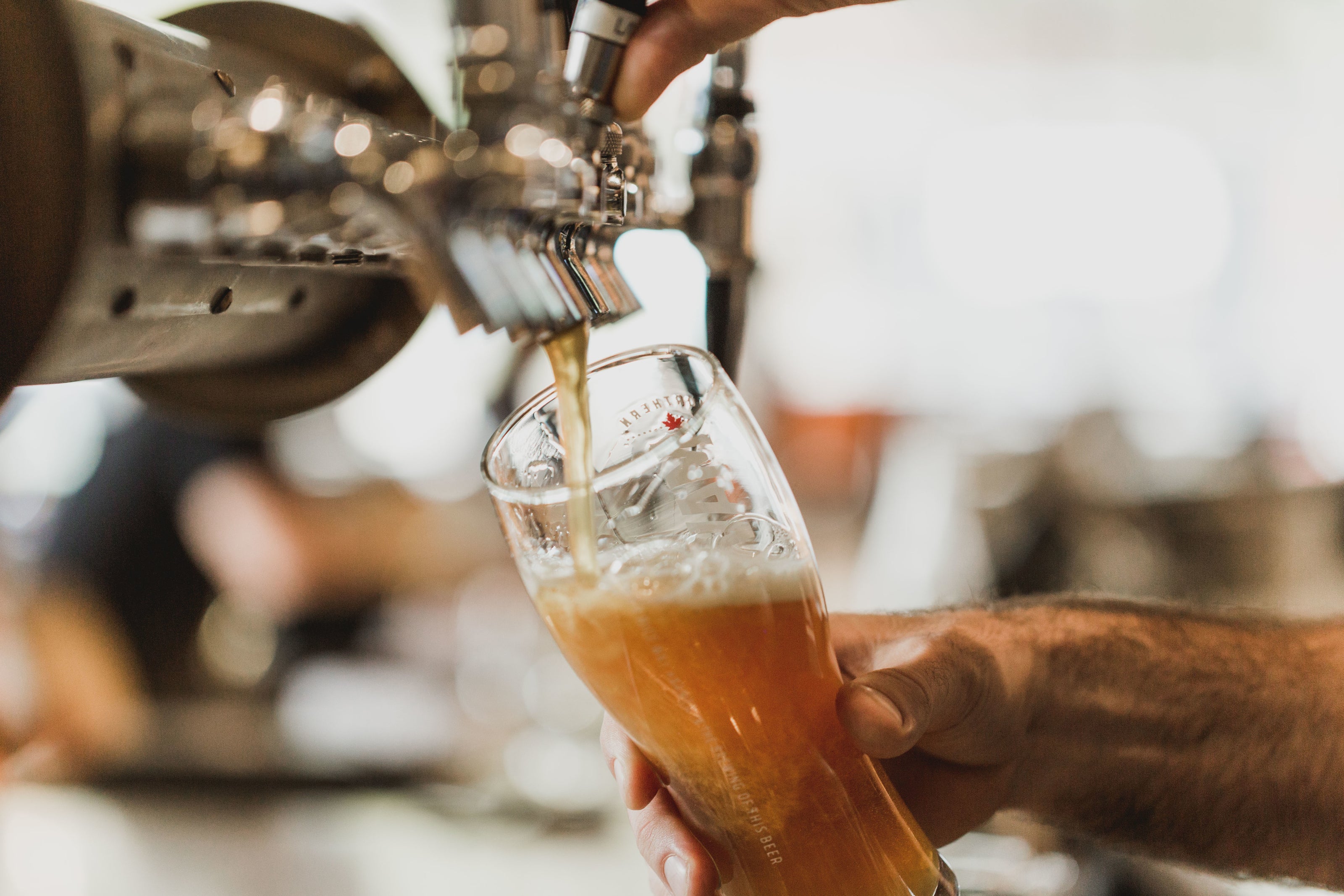man pouring beer from tap