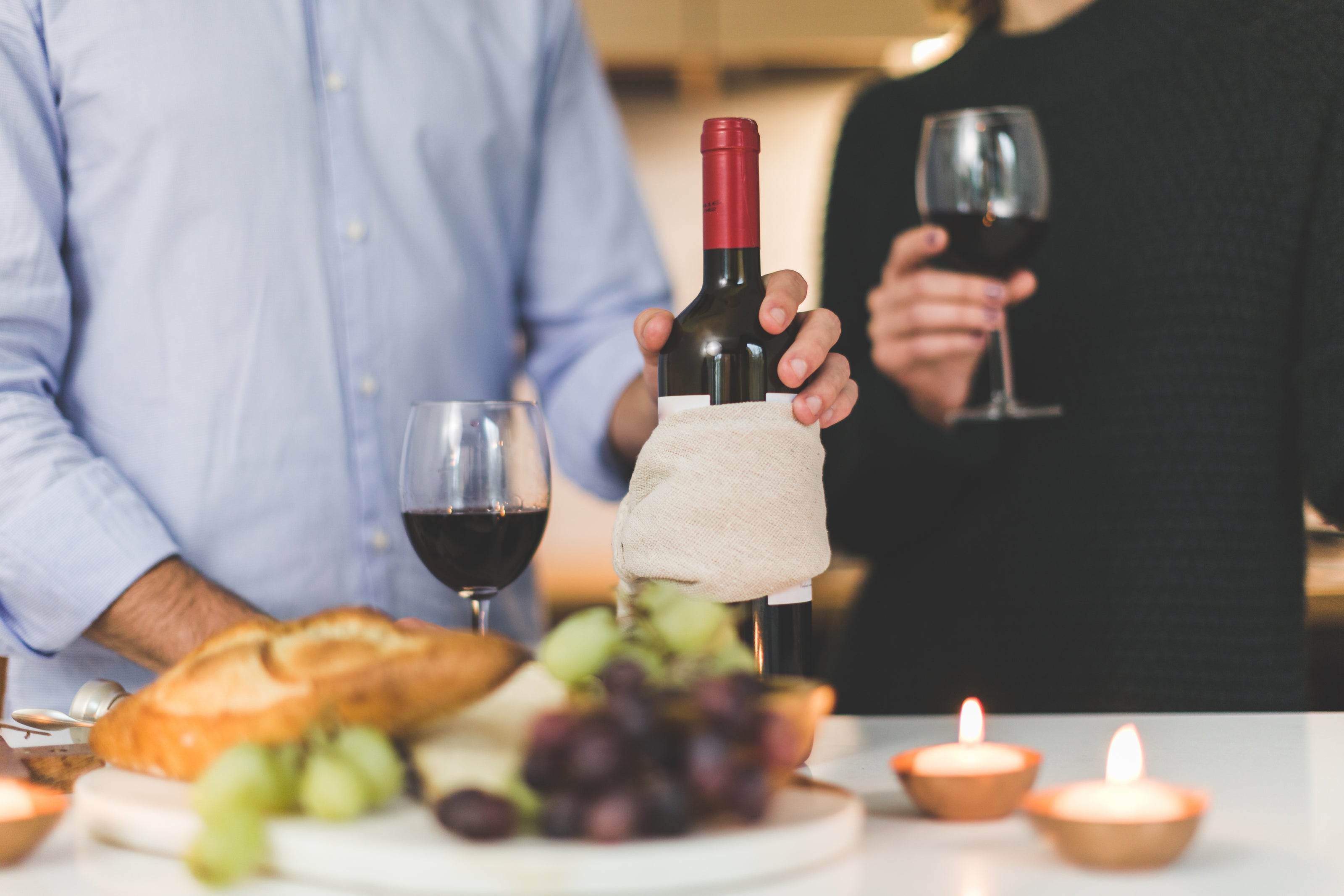 couple enjoying wine, cheese, grapes, and bread