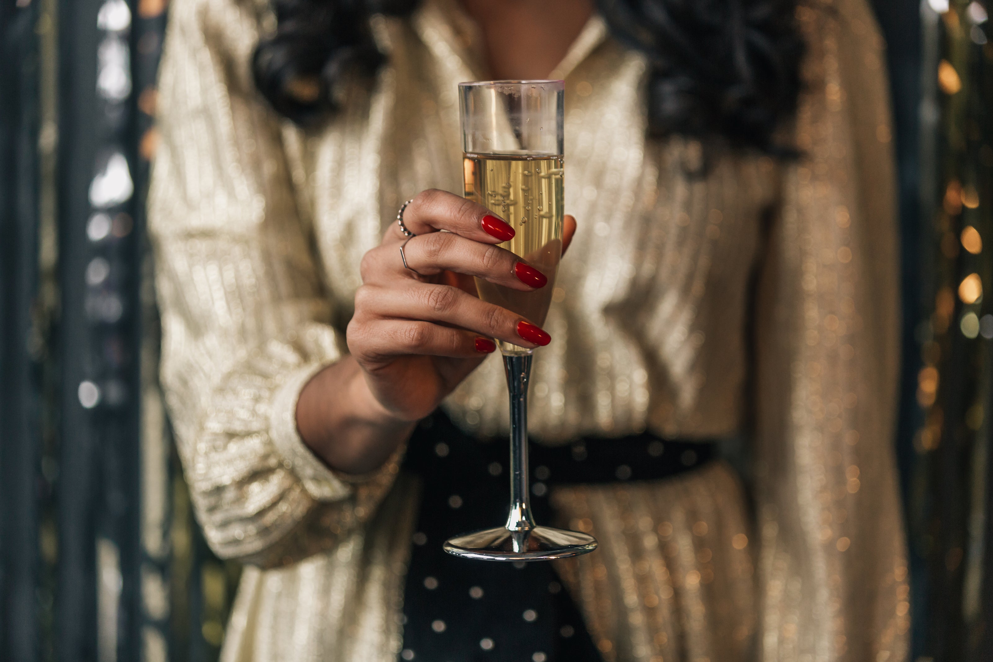 woman wearing party dress holding champagne flute